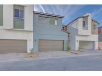 Modern townhome with neutral-colored exterior, two-car garage, and well-kept landscaping at 4341 Sunburst Spring Ave, Las Vegas, NV 89141