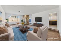 Bright living room features a stone fireplace, plush seating, and an open layout to the kitchen at 720 Sam Jonas Dr, Las Vegas, NV 89145