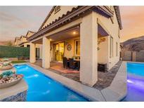 Inviting backyard with a sparkling pool, covered patio, and outdoor dining area perfect for entertaining at 864 Firestone Ledge Ave, Henderson, NV 89012