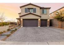 Charming two-story home featuring a three-car garage and attractive brick driveway at 864 Firestone Ledge Ave, Henderson, NV 89012