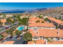 Stunning aerial view of the condos featuring a pool, mountains, and a glimpse of the lake at 107 Topsail Dr, Boulder City, NV 89005