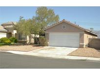 Beige single story home with low maintenance yard and white two car garage door at 108 Zenith Point Ave, North Las Vegas, NV 89032