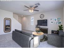 Bright living room with stylish gray sofas, ceiling fan and decorative accents at 4550 Kali Lyn St, North Las Vegas, NV 89031