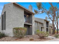 Two-story condo building showcasing a small balcony, chimney and desert landscaping at 584 Sellers Pl, Henderson, NV 89011