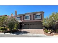 Two-story home showcasing a three-car garage and beautiful brick accents at 6250 Sierra Knolls Ct, Las Vegas, NV 89139