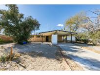 Charming single-story home featuring a covered carport and a spacious front yard with mature trees at 709 N 22Nd St, Las Vegas, NV 89101