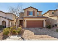 Two-story house with brown garage door and brick driveway at 9875 Vista Meadows Ave, Las Vegas, NV 89148