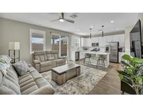 Open living room features a kitchen island and stainless steel appliances at 10211 Starlit Canyon Ct, Las Vegas, NV 89141