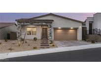 Single-story home with stone accents and a two-car garage at 11671 Hatchling Ave, Las Vegas, NV 89138