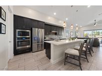 Modern kitchen with stainless steel appliances, a large island with seating, and pendant lighting at 11900 Star Grass Ave, Las Vegas, NV 89138