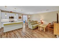 Open concept kitchen and living area with island, stainless steel appliances, and hardwood floors at 1544 Tilman Ln, Boulder City, NV 89005