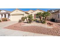 Well-maintained single-story home featuring desert landscaping, small palm trees, and a two-car garage at 2192 Tiger Links Dr, Henderson, NV 89012