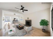 Bright living room featuring a fireplace, ceiling fan, and modern furniture at 353 Keating St, Henderson, NV 89074