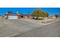 Charming single-story brick home featuring a two-car garage, solar panels, and low-maintenance landscaping at 4424 Shady Hollow Ave, North Las Vegas, NV 89031