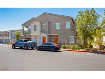 Tan two-story townhome with two-car garage and landscaping at 4495 Violet Flowers St # 2046, North Las Vegas, NV 89031