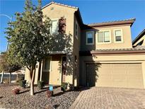 Two story house with tan exterior, brown roof, and a two car garage at 5249 Fiery Sky Ridge St, Las Vegas, NV 89148