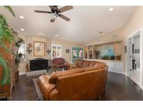 Spacious living room featuring a large leather sectional sofa and a cozy fireplace at 7200 Big Rock Cir, Las Vegas, NV 89129