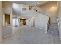 Bright living room features an open floor plan, stairs to the second floor, neutral paint and tile floors at 928 Allure Dr, Las Vegas, NV 89128