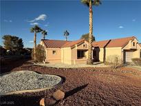 Charming home with a tile roof, desert landscaping, and mature palm trees on a sunny day at 9552 Gold Bank Dr, Las Vegas, NV 89134