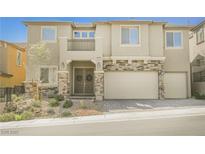 Two-story home with a stone-accented facade, desert landscaping, and multi-car garage at 2795 Athens Ridge Dr, Henderson, NV 89052