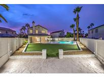 Beautiful backyard features a swimming pool, green lawn, and white perimeter walls offering privacy and style at 336 Merit Ct, Henderson, NV 89014