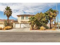 Inviting two-story home with a three-car garage and mature desert landscaping at 6588 Aldergate Ln, Las Vegas, NV 89110