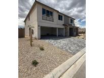 Two-story home with a gray brick driveway and a three-car garage in a modern style at 7199 Twilight Rider Ct, Las Vegas, NV 89118
