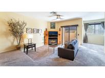 Inviting living room features plush carpet, a cozy fireplace and sliding glass doors to the outdoor space at 4425 Woodpine Dr # 104, Las Vegas, NV 89119