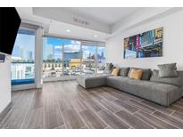 Modern living room features gray sectional, city views, and sleek tile flooring at 4575 Dean Martin Dr # 505, Las Vegas, NV 89103