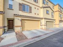 Charming townhome featuring a two-car garage and a welcoming front door with a covered entry at 1525 Spiced Wine Ave # 19103, Henderson, NV 89074