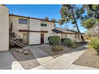 Charming townhouse featuring a well-maintained lawn, mature trees, and covered entryway with convenient stair access at 2333 Wooster Cir # B, Las Vegas, NV 89108