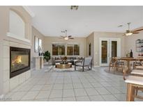 Bright living room featuring a fireplace, ceiling fan and view to the backyard at 2725 Cool Lilac Ave, Henderson, NV 89052