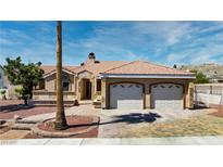 Inviting single-story home featuring a spacious two-car garage, tile roof, and charming desert landscaping at 3665 S Pointe Cir, Laughlin, NV 89029