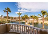 Stunning balcony view overlooking a serene lake and lush palm trees under a bright blue sky at 8208 Horseshoe Bend Ln, Las Vegas, NV 89113