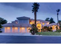 Elegant home featuring a six-car garage, tile roof, and lush landscaping with mature palm trees at 10 Innisbrook Ave, Las Vegas, NV 89113