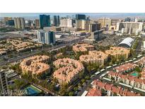 Stunning aerial view of a condominium complex with tennis court against the city skyline at 260 E Flamingo Rd # 113, Las Vegas, NV 89169