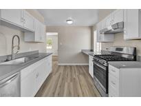 Updated kitchen features new stainless steel appliances, modern white cabinets, and beautiful countertops at 2716 Salt Lake St, North Las Vegas, NV 89030