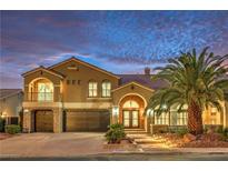 Beautiful two-story home with desert landscaping, driveway, three-car garage, and an inviting arched entryway at 4045 Abernethy Forest Pl, Las Vegas, NV 89141