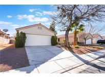 Charming single-story home featuring a two-car garage, desert landscaping, and a cozy front porch, creating an inviting curb appeal at 629 Alecandro Daniel Ave, North Las Vegas, NV 89031