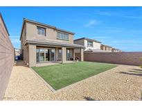 Beautiful backyard featuring an artificial grass area and desert landscaping under a bright blue sky at 12125 Arrebol Ave, Las Vegas, NV 89138