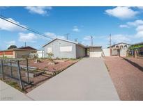 Exterior view of home with a long concrete driveway on a sunny day under a blue sky at 2229 La Puente St, Las Vegas, NV 89115
