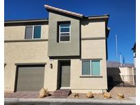Two-story tan home with a one-car garage, neutral trim, and a brick walkway at 2734 Champagne Gold Ave, North Las Vegas, NV 89086