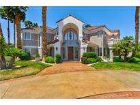 Stunning two-story home with a grand entrance, lush landscaping, and a circular driveway at 3341 Camino Gardens Way, Las Vegas, NV 89146