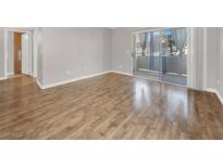 Bright living room with hardwood floors and sliding glass doors to a balcony at 3425 E Russell Rd # 114, Las Vegas, NV 89120