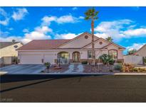 Charming single-story home boasts a well-manicured front yard, and a spacious three-car garage at 7301 Bachelors Button Dr, Las Vegas, NV 89131