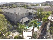 Stunning aerial view of home featuring a backyard pool and a tile roof in a desert landscape at 861 Majestic Ridge Ct, Henderson, NV 89052