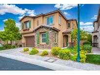 Charming two-story home featuring a stone facade, landscaped yard, and a two-car garage, under a bright blue sky at 12240 Old Muirfield St, Las Vegas, NV 89141