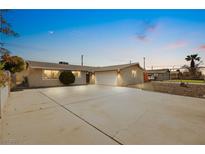 Charming single-story home with a spacious driveway and well-maintained landscaping under a beautiful sky at 1516 Saylor Way, Las Vegas, NV 89108