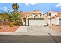 Charming single-story home featuring a tile roof, well-kept yard and an attached two-car garage at 1904 Monte Alban Dr, North Las Vegas, NV 89031