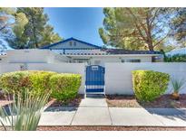 Charming single story home featuring a blue metal fence, manicured landscaping, and a blue-tiled roof at 2141 Twickenham Pl # A, Las Vegas, NV 89108